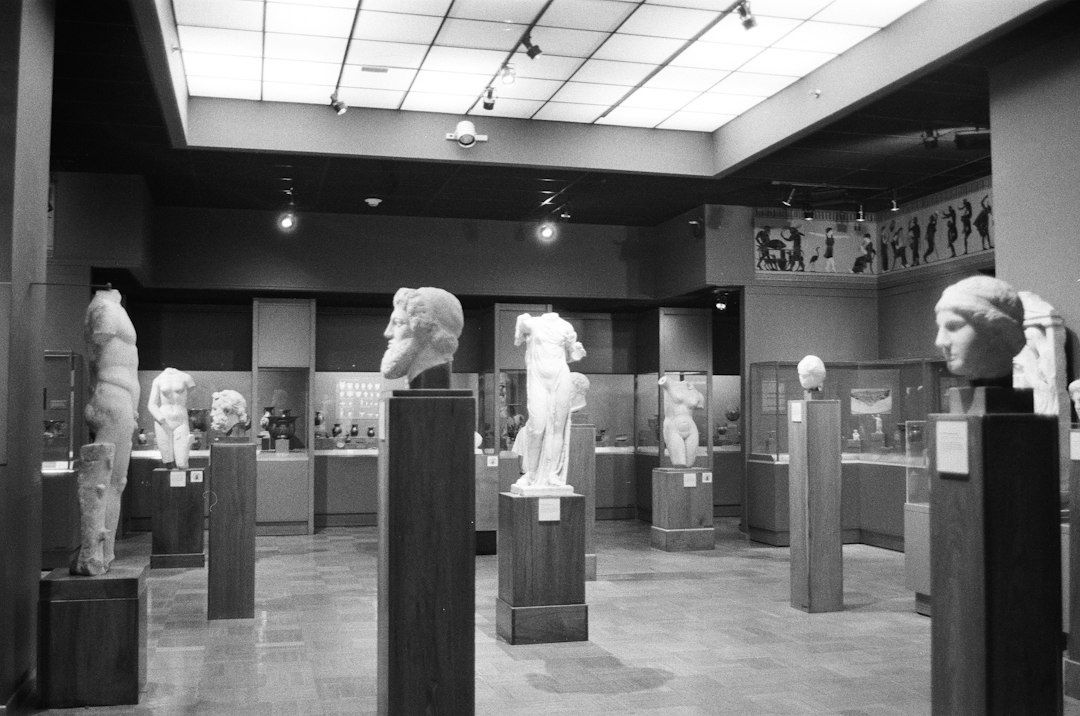 Black-and-white museum gallery displaying classical sculptures and artifacts
