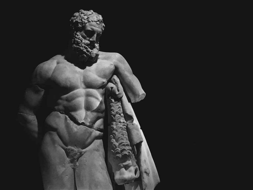 Black-and-white view of a weathered bearded ancient statue